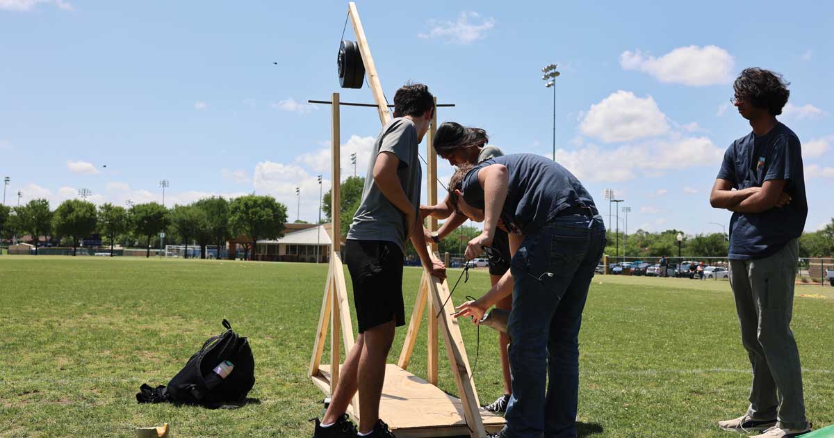 Engineering and History Students launch projectiles with a trebuchet