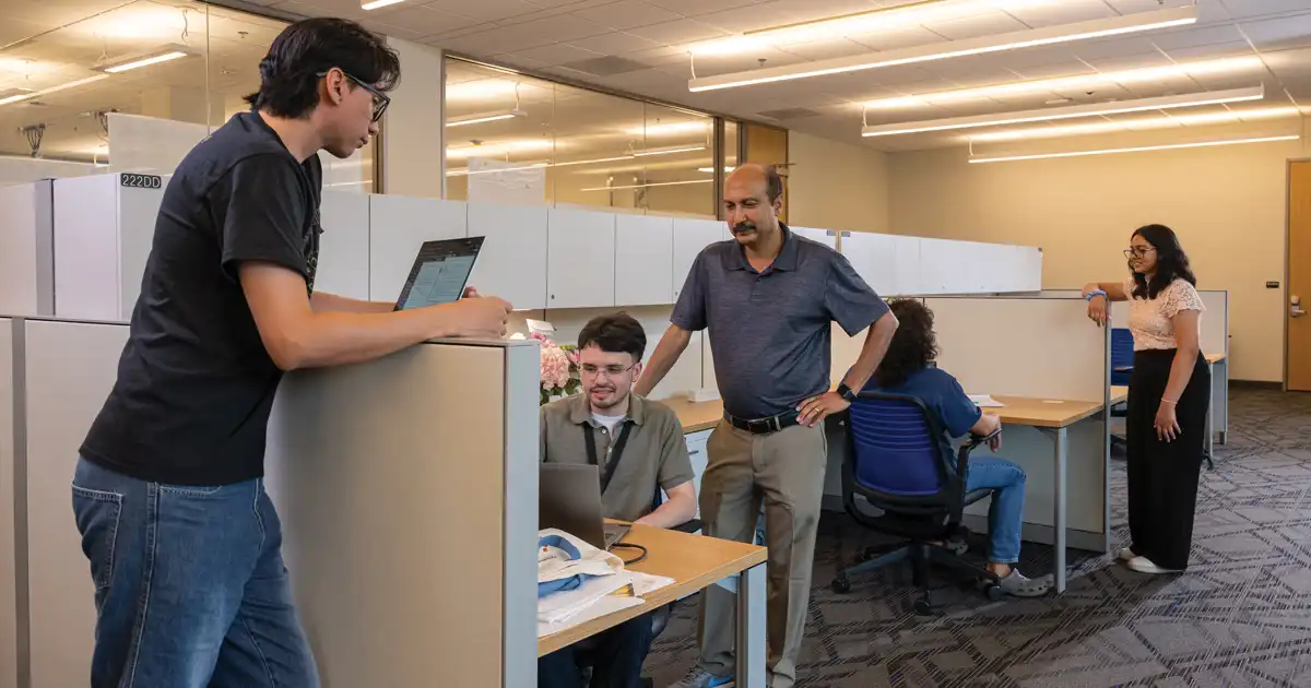 Faculty and students working on laptops